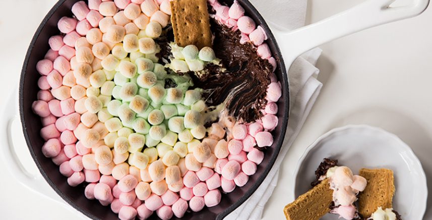 skillet with warm chocolate chips and colorful marshmallows to dip graham crackers in