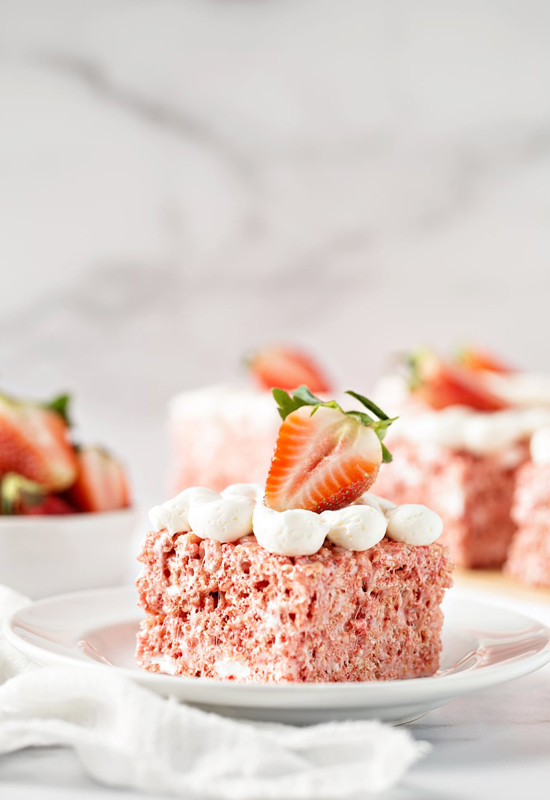Strawberry Rice Krispie Treats on plates with strawberries