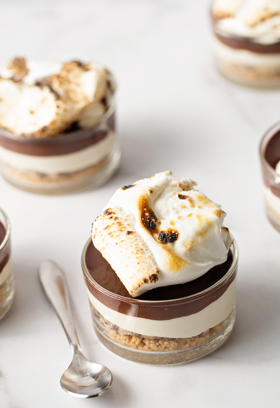 No Bake Cookie Dough S'mores Cheesecakes on counter with spoon